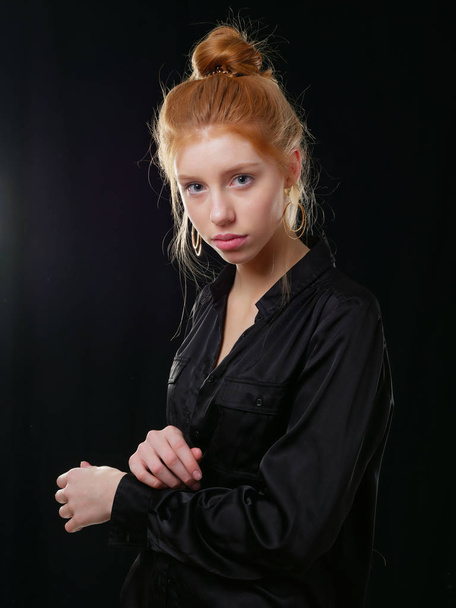 chica joven con el pelo largo y rojo sobre un fondo negro
 - Foto, imagen