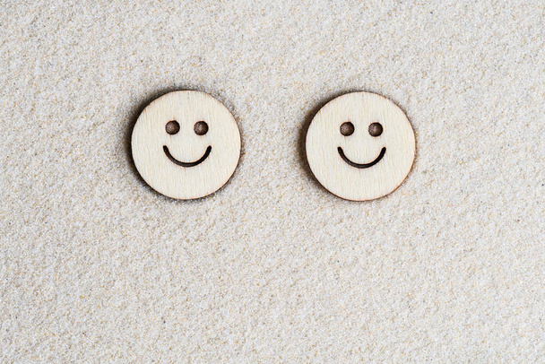 Two funny happy wooden smile face on the sand at the beach. Concept. Flat lay. Aerial view - Foto, Imagem