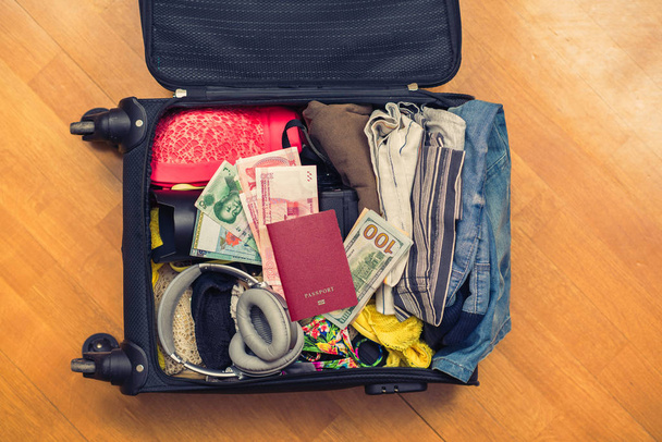 Suitcase full of clothes on the floor. Travel concept - Φωτογραφία, εικόνα