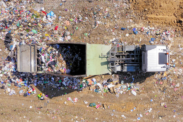Сортировка промышленных отходов и отгрузка металлолома, с экскаватором и прицепами, загруженными различными видами спасенных металлов - Фото, изображение