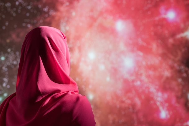 Gece havai fişekler sırasında kırmızı eşarplı Müslüman bir kadın..   - Fotoğraf, Görsel