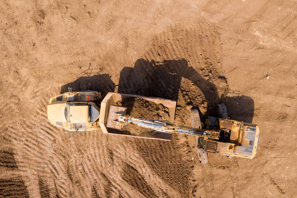 A talajt ízesített kamionokra rakodó kotrógépek légi rálátása - Fotó, kép
