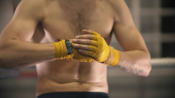 Un boxeur homme avec les mains bandées assis sur le ring
 - Photo, image