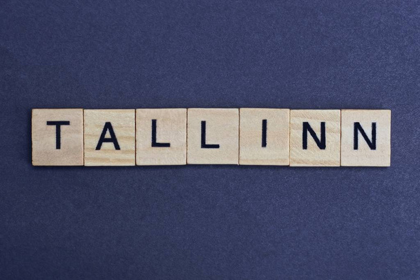  gray word tallinn from small wooden letters on a black table - Фото, изображение