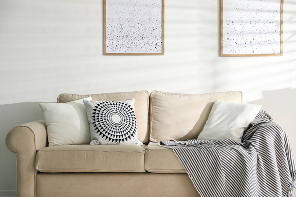 Travesseiros decorativos elegantes no sofá bege dentro de casa
 - Foto, Imagem