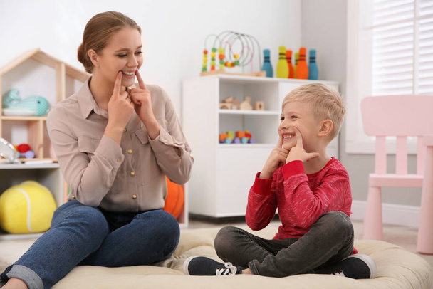 Speech therapist working with little boy in office - Фото, зображення