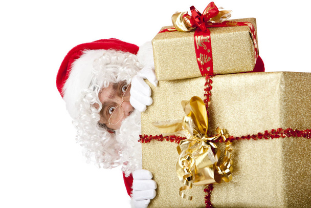Santa Claus is hiding behind Christmas gift boxes - Photo, Image