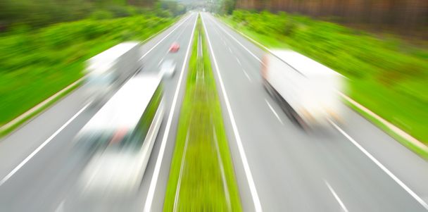 beweging wazig vrachtwagens op de snelweg. transport industrie concept. - Foto, afbeelding