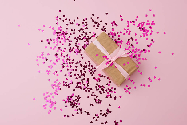 caixa de presente marrom envolto em papel e amarrado com fita rosa de seda
  - Foto, Imagem