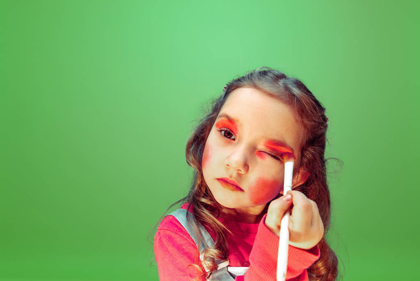 Little girl dreaming about future profession of makeup and hairstyle artist - Foto, imagen