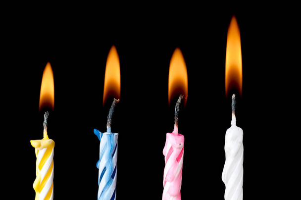 Horizontal burning birthday candles on black - Foto, Imagen