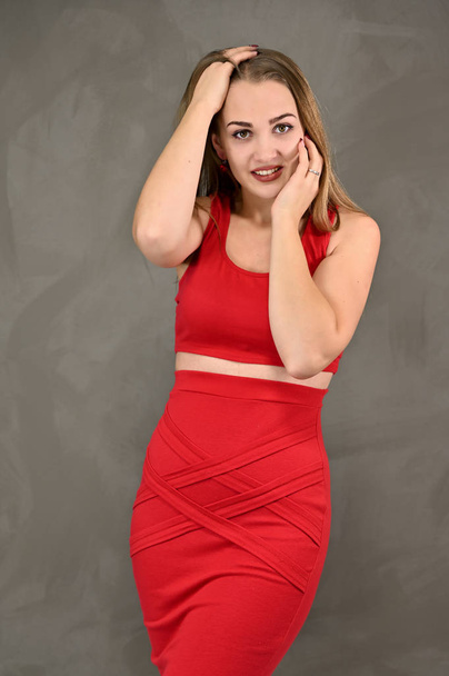 Vertical photo of a pretty smiling girl with long hair and great makeup in a red dress with emotions in different poses. Universal concept of a female portrait. - Фото, изображение