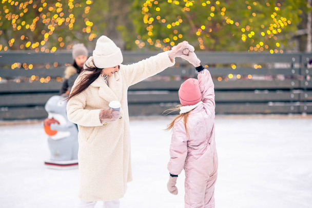 Little adorable girl with her mother skating on ice-rink - Photo, Image