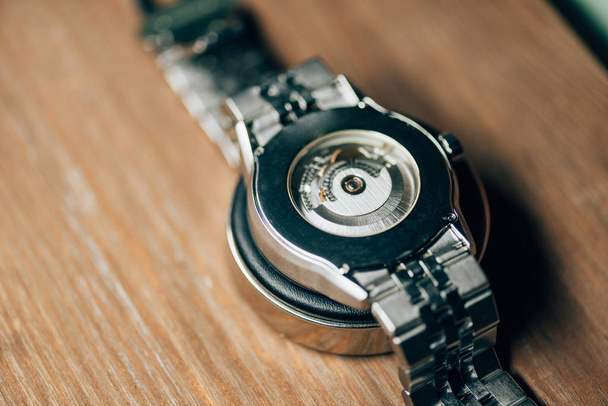 Close up view of mechanical wristwatch on stand on wooden table - Фото, зображення