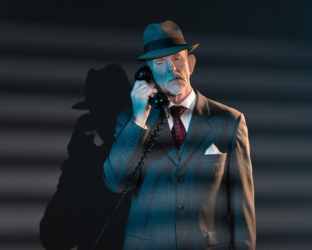 Retro detective man calling with vintage telephone at night in o - Photo, Image