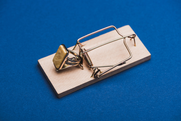 Jewellery ring in mouse trap on blue background - Photo, Image