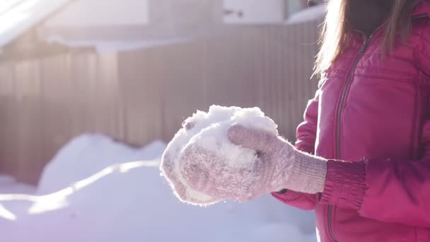 Kobieta wymiotuje świeżym śniegiem, wczesną zimą. ferie zimowe, zima, słoneczny dzień. ukierunkowanie selektywne - Materiał filmowy, wideo