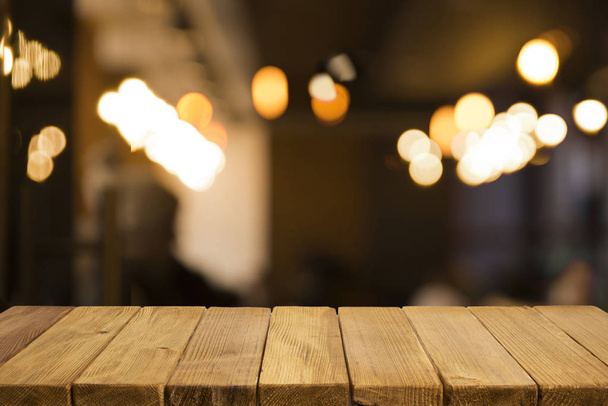 Lege bruine houten tafel en wazige achtergrond van abstracte resturant licht mensen genieten van eten, kan worden gebruikt voor montage of display uw producten - Foto, afbeelding