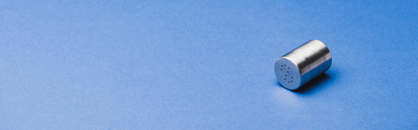 Panoramic shot of metallic salt shaker on blue background - Φωτογραφία, εικόνα