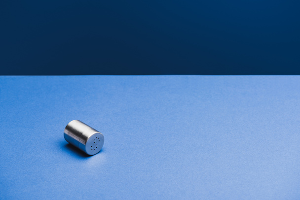 metallischer Salzkeller mit Schatten auf klassisch blauem Hintergrund - Foto, Bild