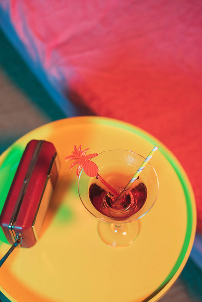 Yellow table with cocktail drink and portable radio next to sunb - Photo, Image