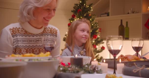 Little caucasian girl granddaughter with grandmother christmas dinner family smile - Πλάνα, βίντεο