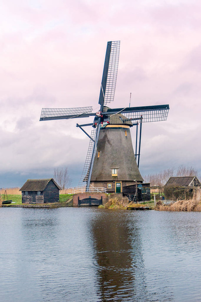 Molinos de viento y un cielo muy nublado en el invierno, en el paseo marítimo en Kinderdijk un patrimonio nacional en el Alblasserwaard
 - Foto, Imagen