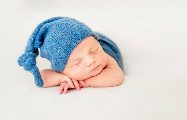 Cute boy in blue bonnet sleeping - Fotó, kép