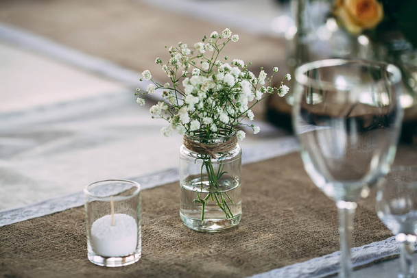 Small dry flowers bush in vase on decorated vintage style table - Foto, Bild