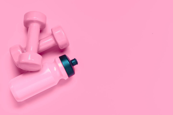 Koncepcja tła treningu fitness z różowymi hantlami i butelką - Zdjęcie, obraz