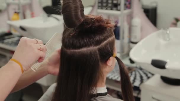 Profesjonalna kobieta fryzjer przygotowuje klientów włosy do fryzjera. - Materiał filmowy, wideo