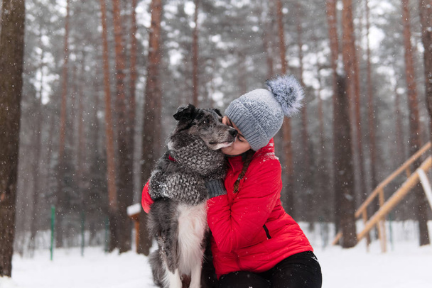 young woman wits her dog in a winter park - Foto, Imagem