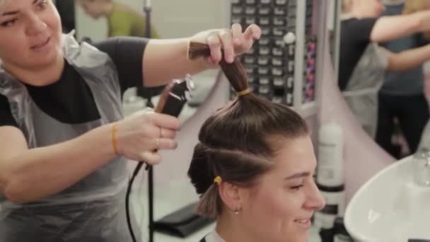 Profesjonalny fryzjer kobieta cięcia włosów do klienta z strzyżenia włosów. - Materiał filmowy, wideo