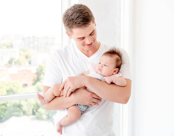Father embracing infant - Φωτογραφία, εικόνα