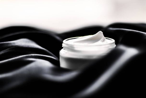 Πολυτέλεια ευαίσθητη επιδερμίδα ενυδατική κρέμα προσώπου σε μαύρο μετάξι  - Φωτογραφία, εικόνα