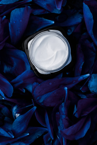 Κρέμα προσώπου πολυτελείας για το δέρμα του προσώπου σε μπλε bac λουλούδι - Φωτογραφία, εικόνα