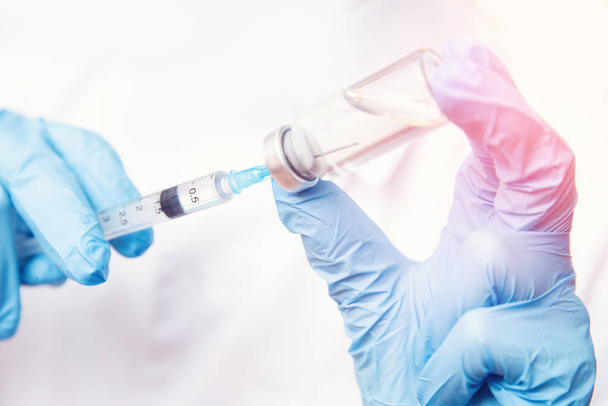 Orvos kézfogó fecskendő és vakcina corona vírus. Betegség injekció Kína az emberek számára koncepció - Fotó, kép