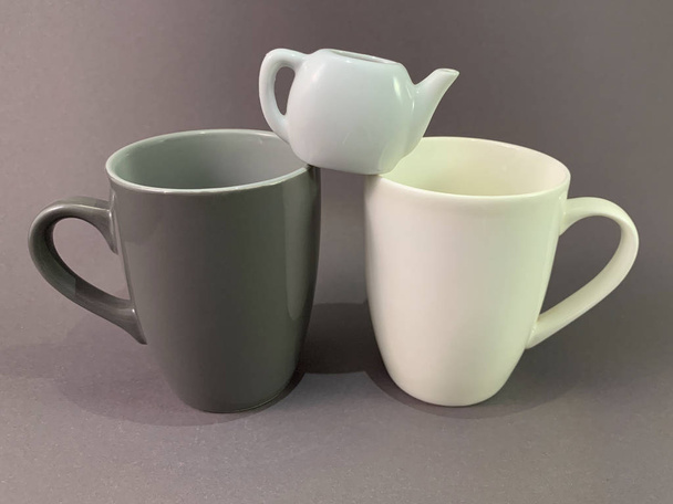 Deux tasses et une petite bouilloire sur fond gris. Tasse sombre et légère pour thé ou café. Concept : amour, thé pour deux, Saint Valentin
. - Photo, image