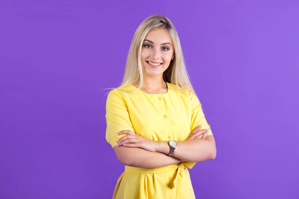 beautiful young woman in a yellow dress on a purple background with her hair - Fotografie, Obrázek