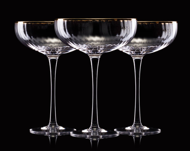 Set of empty luxury champagne glasses in a row isolated on a black background - Foto, afbeelding