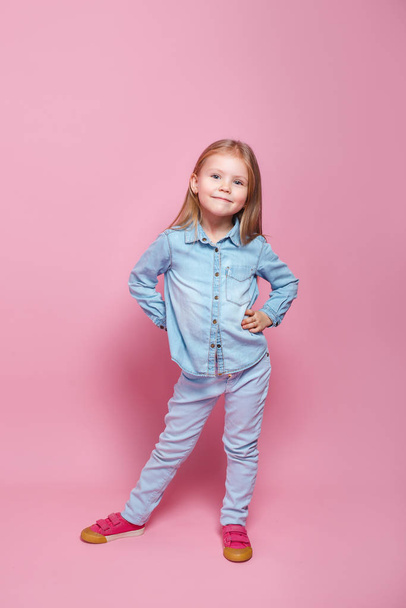 Cute little girl in blue clothes smiling on camera - Foto, Imagem