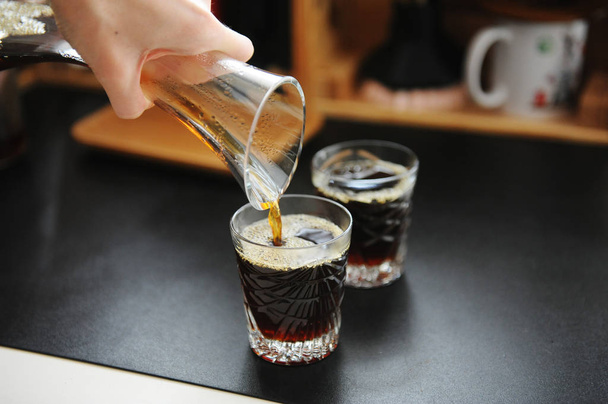 Filterkaffee aus der Karaffe in Gläser gießen. Handbrauen Stillleben. Dritte Welle der Speicherästhetik - Foto, Bild