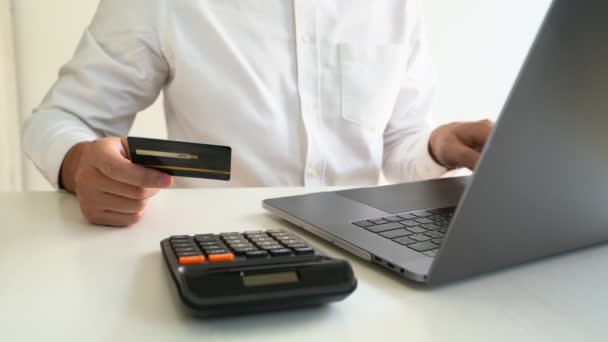 Vídeo de 4k de manos con tarjeta de crédito y el uso de portátil en la oficina de casa, pago y concepto de compras en línea. - Metraje, vídeo