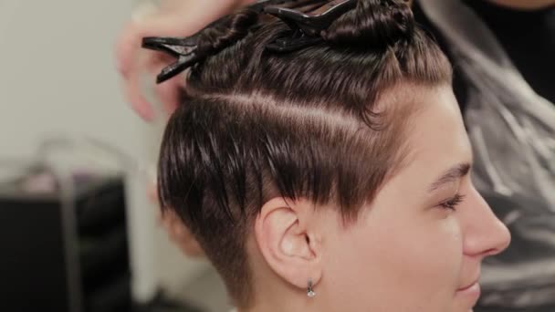 Профессиональный парикмахер женщина делает прическу на мокрые волосы для клиента
. - Кадры, видео