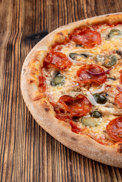 sehr scharfe und würzige Pizza mit Jalapeño, Peperoni und roten Zwiebeln auf Holzboden - Foto, Bild