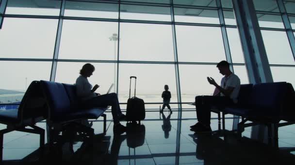 Gezin met kind wachtend op hun vlucht op luchthaven terminal - Video