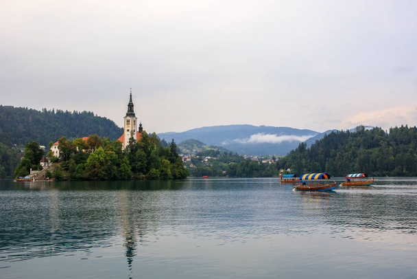 Τουρίστες στο σκάφος Pletna στη λίμνη Bled, Σλοβενία - Φωτογραφία, εικόνα