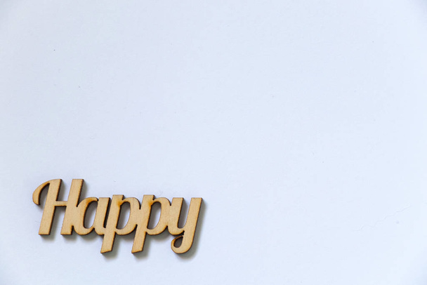 Palabra feliz hecha de letras de madera se encuentra sobre un fondo blanco
 - Foto, Imagen