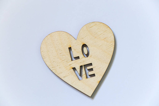 καρδιά από ξύλο με την επιγραφή αγάπη σε λευκό φόντο, συναισθήματα και συναισθήματα - Φωτογραφία, εικόνα