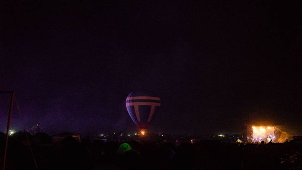 Hot air ballon vliegen over spectaculaire Cappadocië onder de hemel met melkachtige manier en stralende ster 's nachts   - Foto, afbeelding